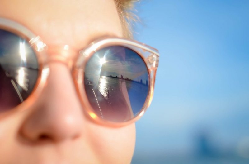 Jovem mulher usa óculos de grau com lentes de sol