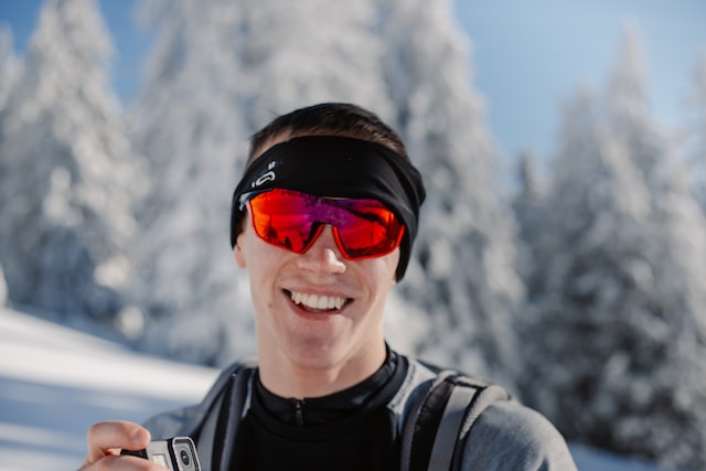 Homem usa óculos com lente vermelha em esporte na neve