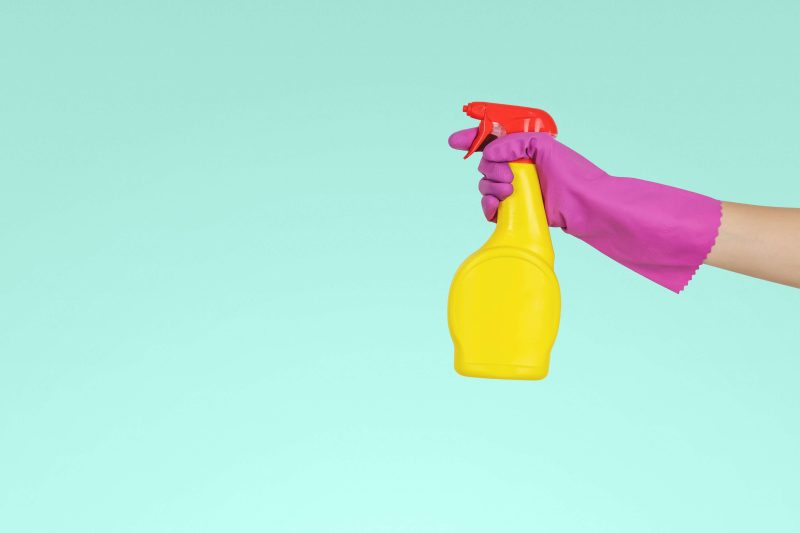 Mulher com luva de limpeza e detergente - Foto: JESHOOTS.COM on Unsplash