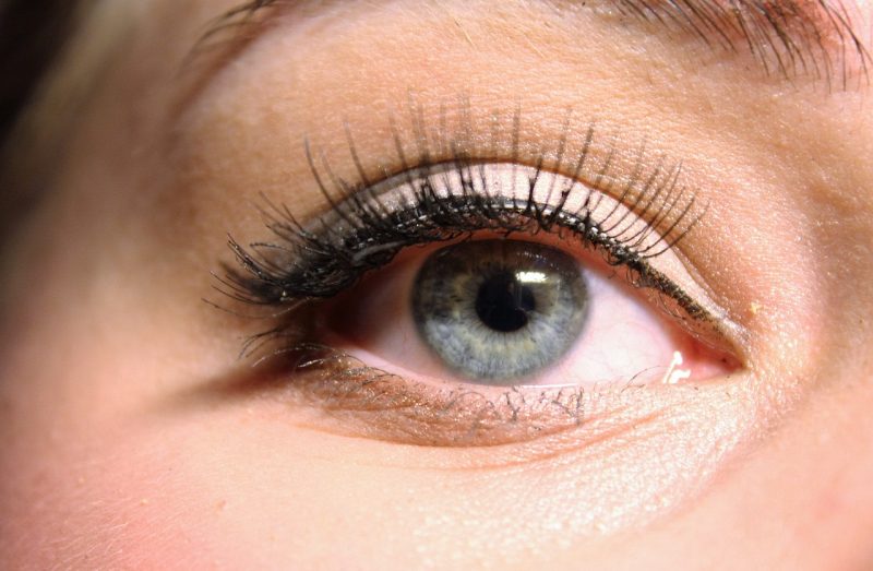 Mulher de olho azul com cílios postiços